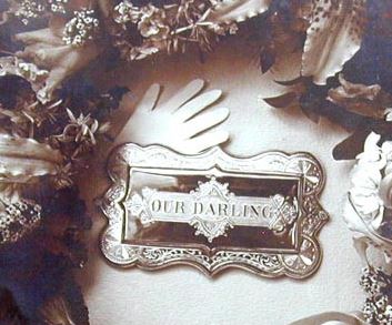 Coffin plate photographed with wreath. See below for full image.